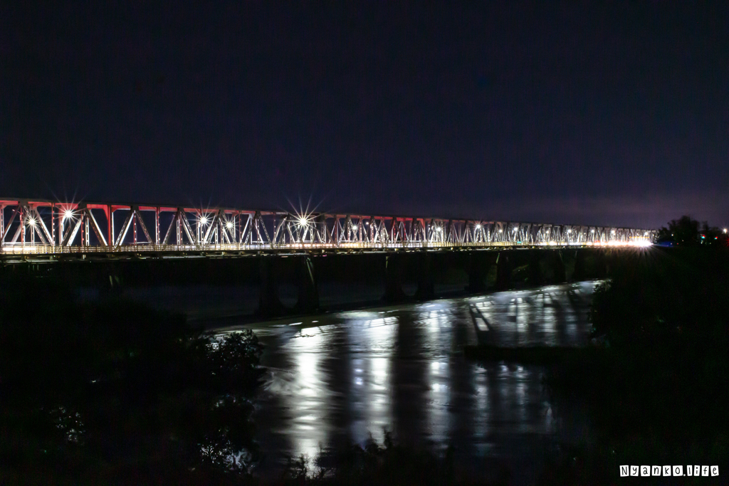 夕闇の大河にかかる光の鉄橋